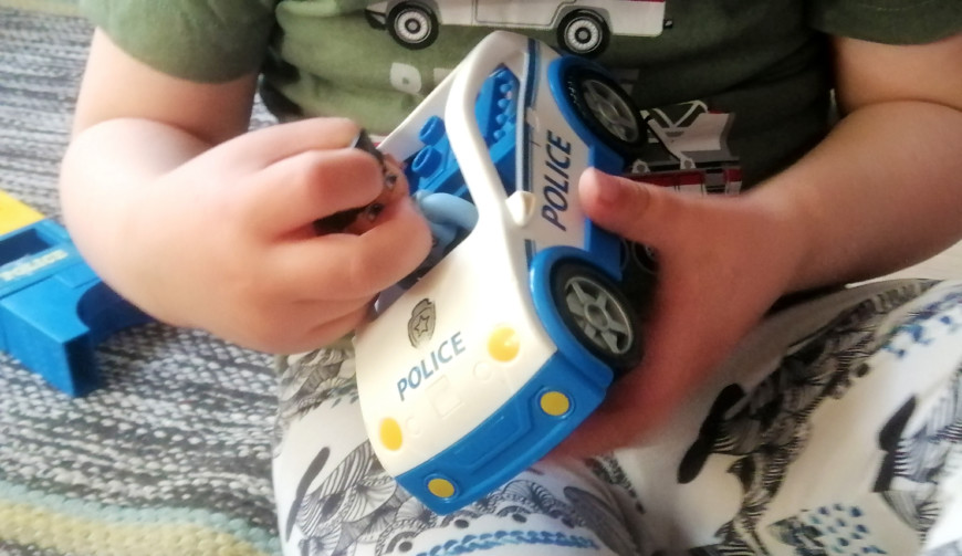 Pieni lapsi leikkii poliisi-Legoautolla