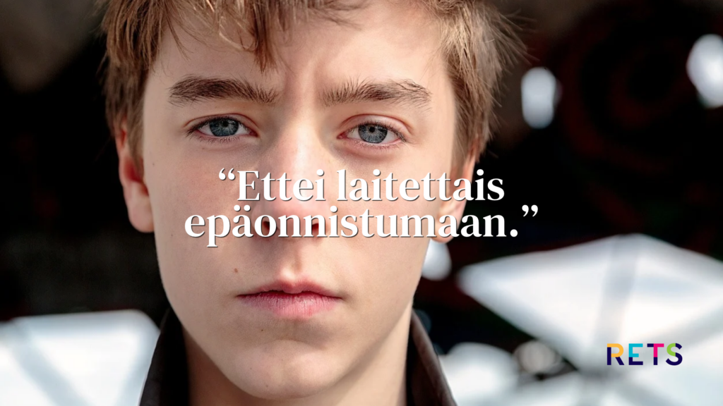 Lähikuva nuoresta pojasta, joka katsoo vakavana suoraan kameraan.